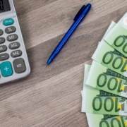 grundstück verkaufen steuer umgehe, Euro mit Taschenrechner und Stift auf dem Tisch