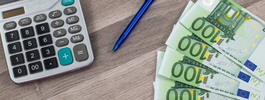 grundstück verkaufen steuer umgehe, Euro mit Taschenrechner und Stift auf dem Tisch